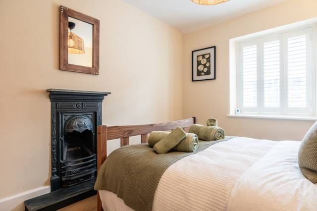 Original fireplace and mirror in the double bedroom of the characterful Somerset cottage
