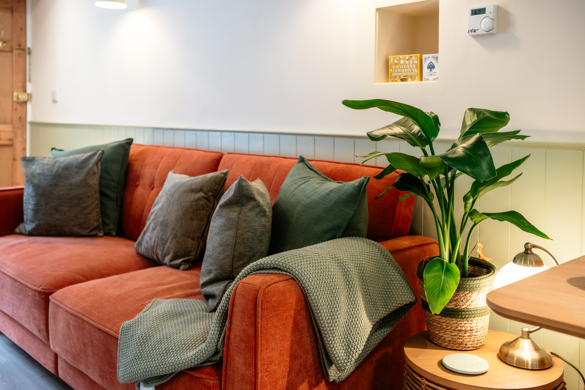Terracotta sofa with cushions and a throw in the sitting room at No. 48 Magdalene Street