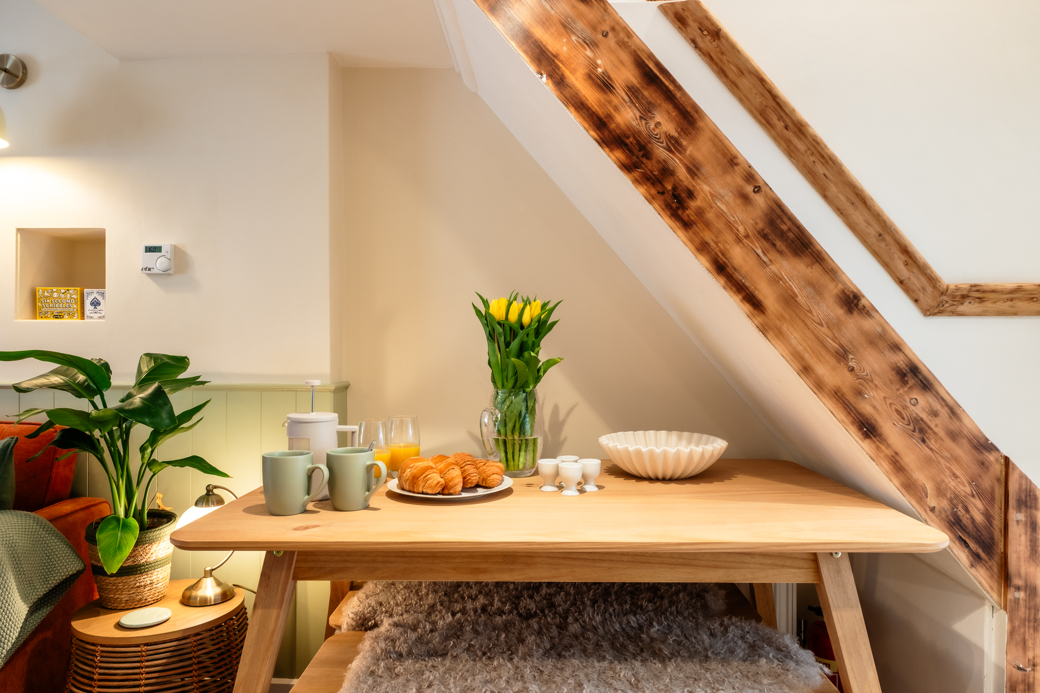 Breakfast table set with tulips and croissants beneath the staircase at No. 48 Magdalene Street