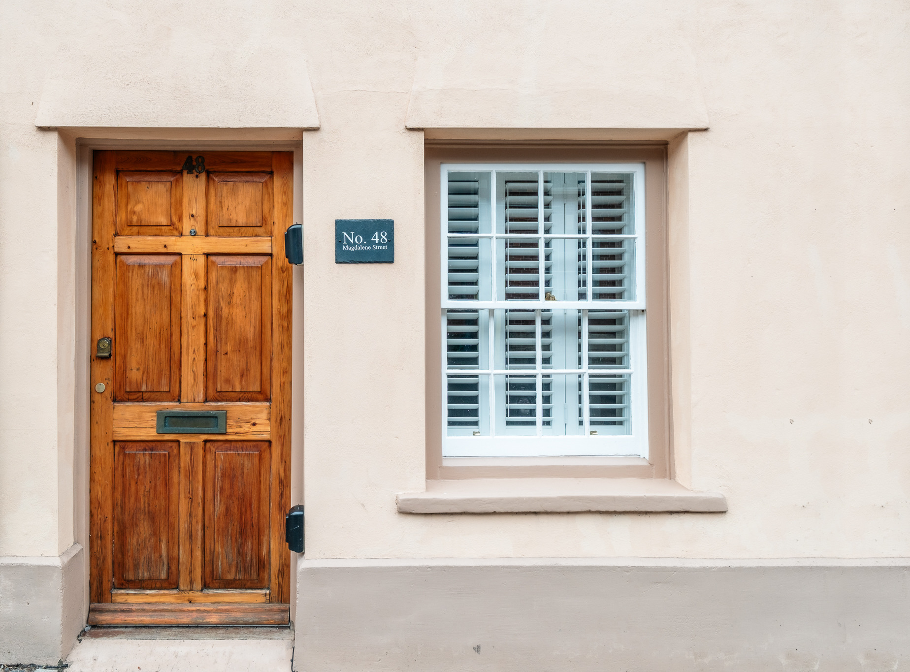 The front door of No. 48 Magdalene Street, a Glastonbury holiday cottage, with its brass house number plaque