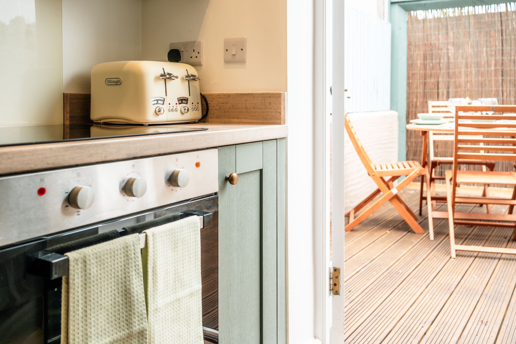 Kitchen with doors open onto the deck at No. 48 Magdalene Street, oven and toaster in view