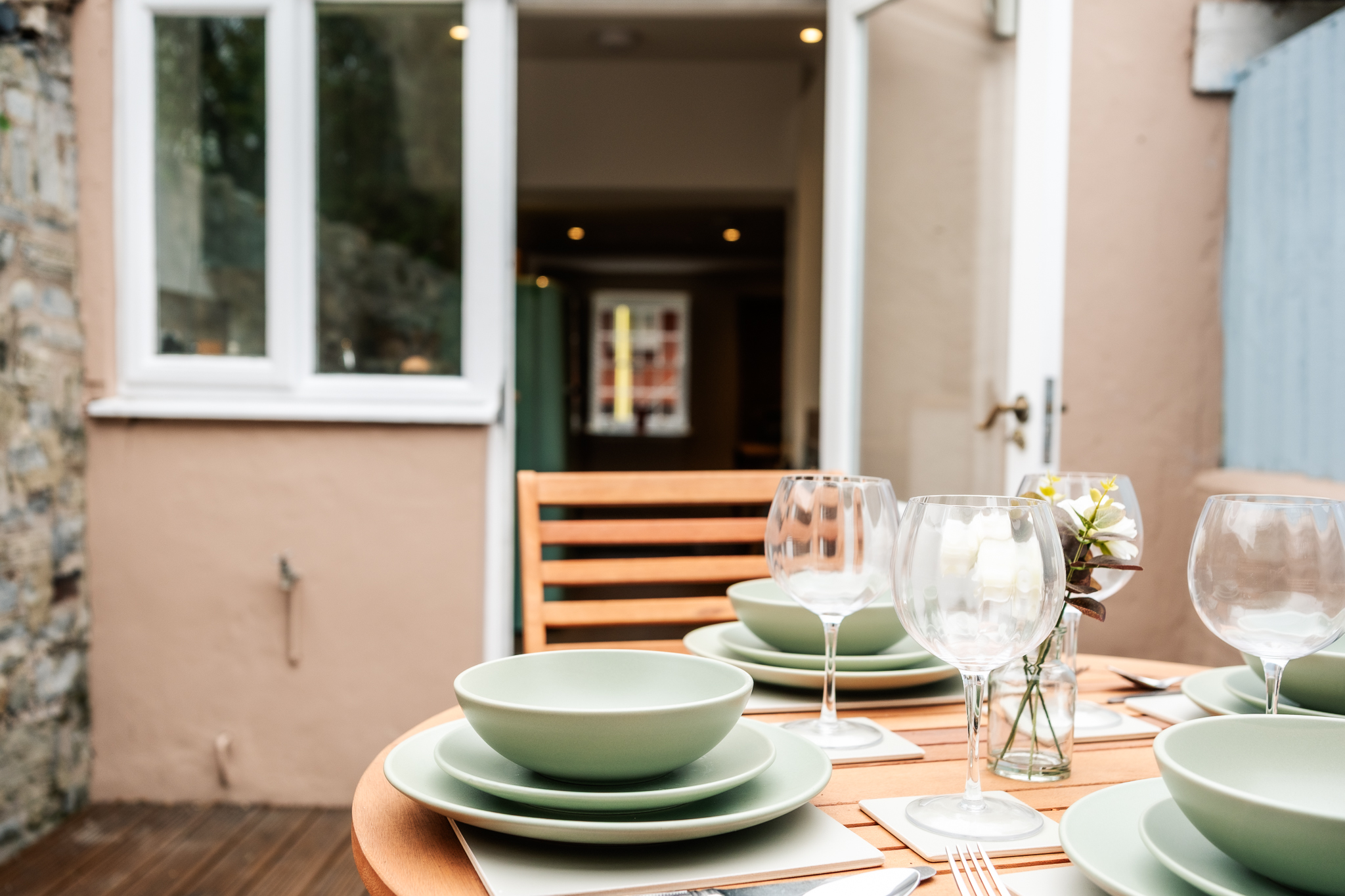 Table set for dinner on the private deck at No. 48 Magdalene Street, with the cottage doorway beyond