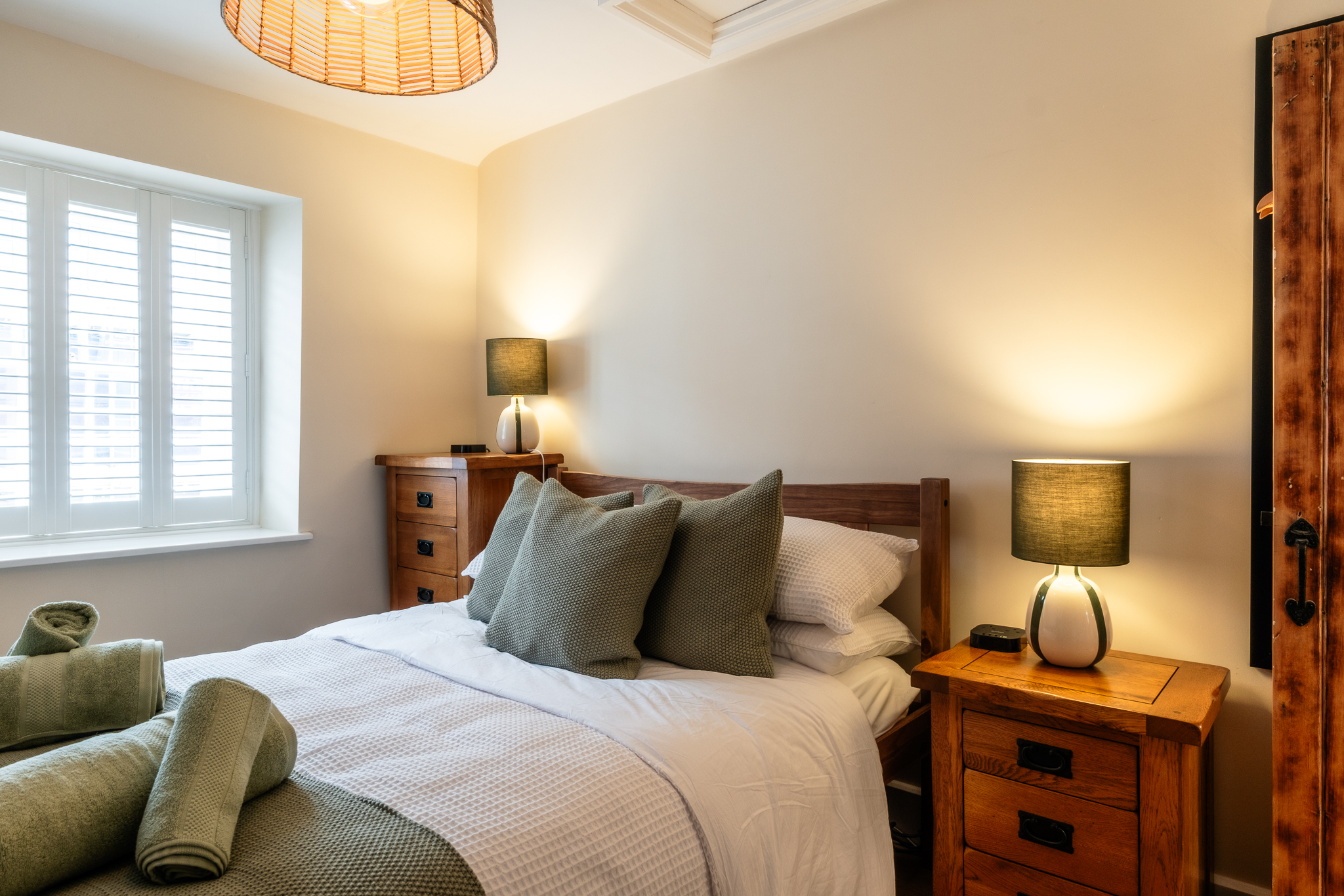 Bright double bedroom upstairs at No. 48 Magdalene Street with wooden bedside tables and green lamps